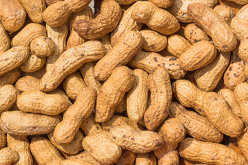 Peanuts in shell texture background. Raw peanuts on display at a farmer's market.