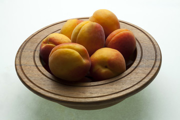 A selection of fresh apricots placed in a wooden bowl_2