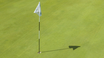 Obraz premium Dettaglio della buca finale di percorso di un campo di golf. Il prato fa parte di un ampio e ricco circolo di golf italiano frequentato dai migliori giocatori del panorama sportivo.