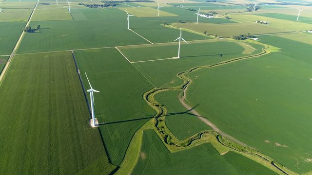 High angle aerial view of wind farm turbines on green agriculture fields