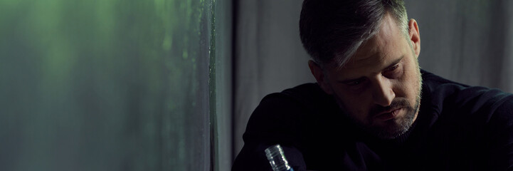 Man in despair holding bottle