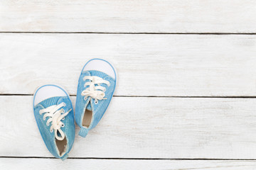 Blue sneakers for a little boy on a white wooden background. Mock up
