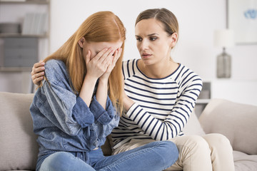 Depressed woman comforted by friend