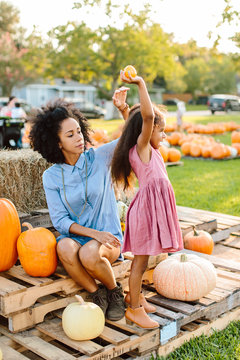 A little girl excited about her pumpkins with her mom