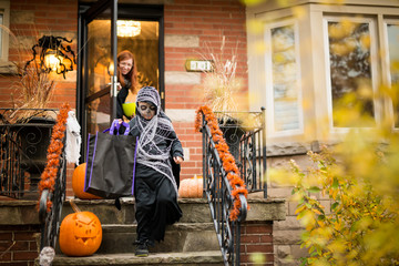 Boy Going Door To Door Trick or Treat at Halloween