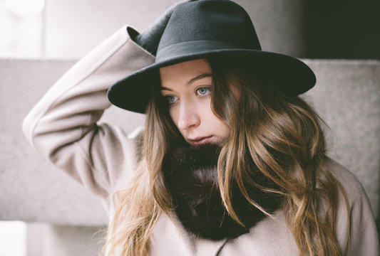 portrait of young woman with hat on the street