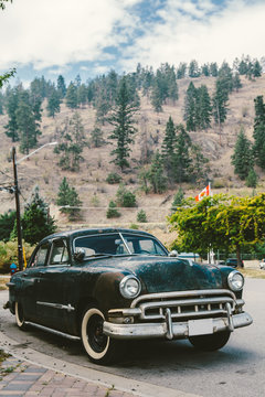 Old car in the street with mountains behind