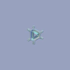 Snowflake isolated on uniform blue background. Macro photo of real snow crystal: small triangular star plate with six simple straight arms and glossy, relief central triangle.