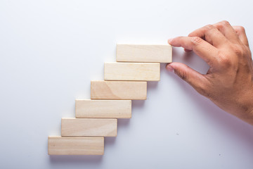 Hand aranging wood block stacking as step stair. Business concept for growth success process.