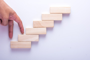 climbing up stairs made up by wooden blocks on white with clipping path