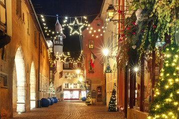 Fototapeta na wymiar Traditional Alsatian half-timbered houses in old town of Colmar, decorated and illuminated at christmas time, Alsace, France