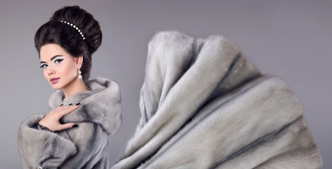 Fashion photo of woman in mink fur coat. Elegant brunette with makeup, hairstyle, manicured nails....