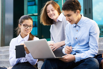 Group of Children Using Laptop by School Building