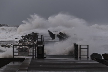    waves hitting against the pier during the storm in Nr. Vorupoer on the North Sea coast in...