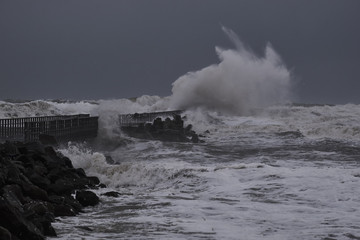    waves hitting against the pier during storm in Nr. Vorupoer on the North Sea coast in Denmark                            