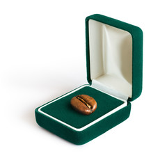 Present / Creative concept photo of a jewelry box with a coffee bean on white background.