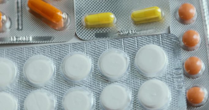 Pills and drugs turning. Close-up of many different turning pills. Medicine, pills and tablets with blister packs turning in a seamless loop.