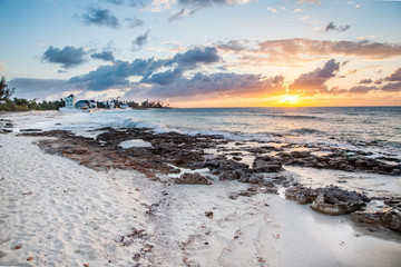 Sunset beach with rocks during low tide in Bahamas