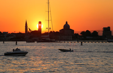 sun at sunset in VENICE in Italy and the shape of the churches a