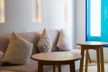 Interior of room with sofa pillow, and small table.