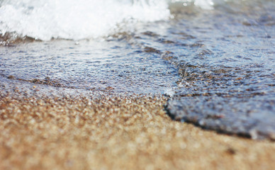 Fototapeta na wymiar Wet sand and waves on the sea