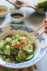 Cucumber salad in Chinese chopsticks, Asian cuisine, spices