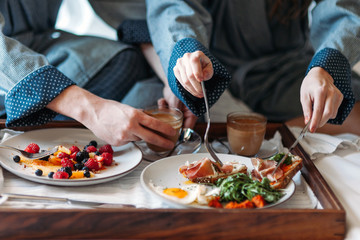 Young couple enjoying room service in bed