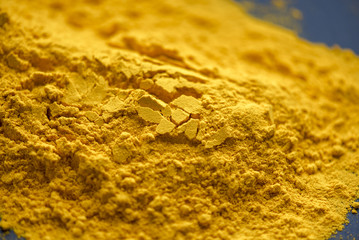 Close-up powder of turmeric, handful of turmeric on the table
