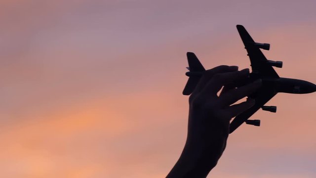 toy boeing in hand in the sky
