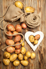 Obraz na płótnie Canvas Potatoes, bag with rope, heart on a wooden background