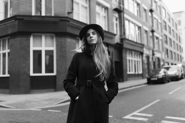 Young elegant woman in the street with hat and coat