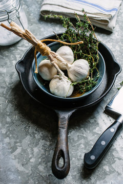 Thyme and bulbs of garlic ready to be prepared for a recipe.