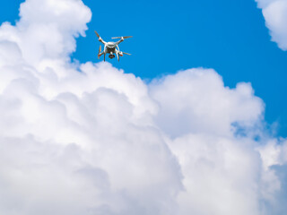 Drone in the blue sky. Quadrocopter hovered in the air.