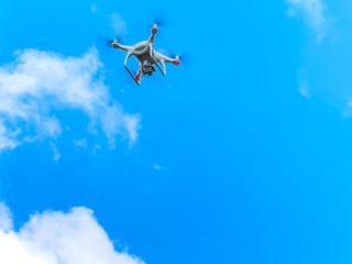 Drone in the blue sky. Quadrocopter hovered in the air.