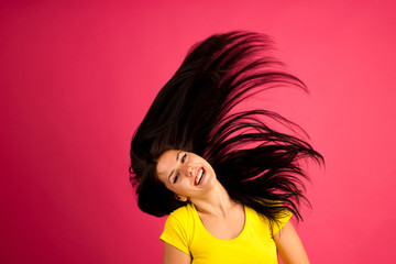 Fototapeta premium attractive young woman listens music over pink background
