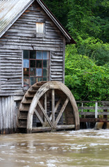Rural landscape with old wooden watermill in woods.