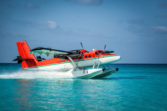 Landing seaplane in the ocean lagoon. The takeoff of a seaplane at ocean beach.