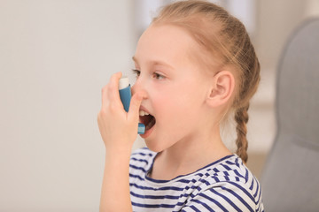 Girl using inhaler during asthmatic attack at home