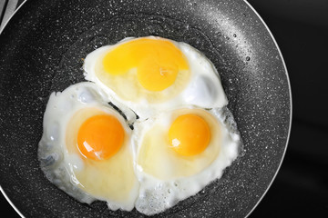 Frying pan with delicious eggs, closeup