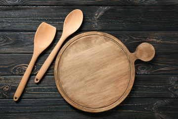 Board and utensils on wooden background