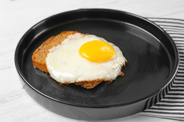 Delicious over easy egg with bread on kitchen table