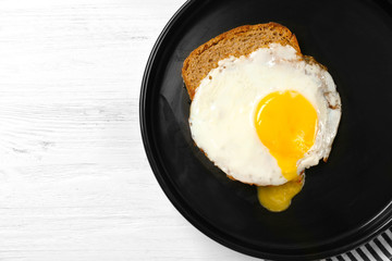 Delicious over easy egg with bread on kitchen table