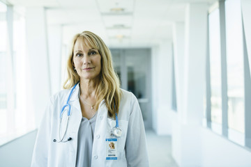 Portrait of confident, happy female doctor in hospital hallway - Powered by Adobe