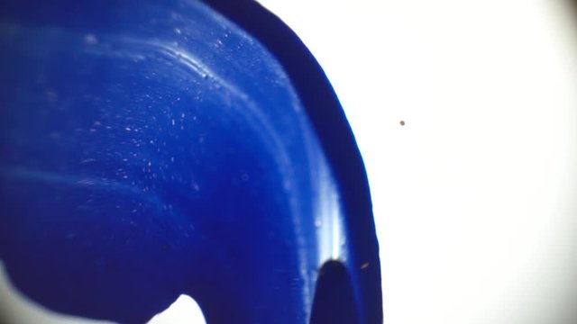Macro photography as a putty knife smears paint on the glass
