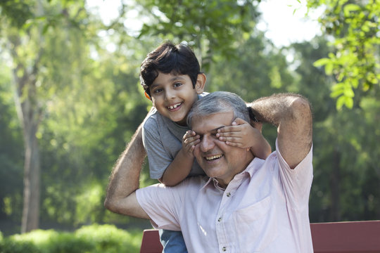 Grandson covering grandfathers eyes