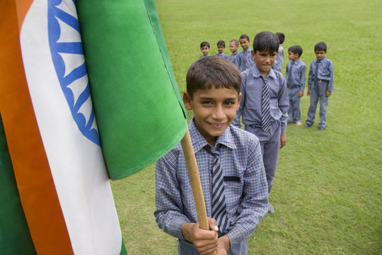 Portrait of a school boy holding the Indian flag 