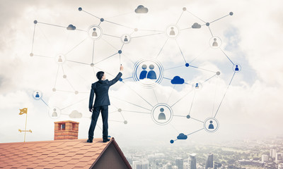 Businessman on house roof presenting networking and connection c