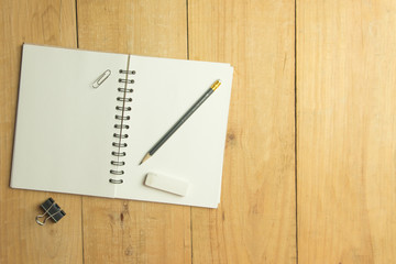 Blank book and pencil and eraser and binder clip. copy space