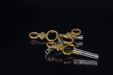 Three Antique Brass Pocket Watch Keys Laying In The Darkness