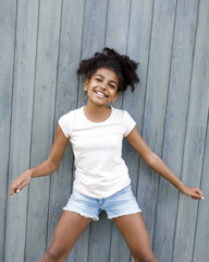 Adorable little girl posing at wall outdoors